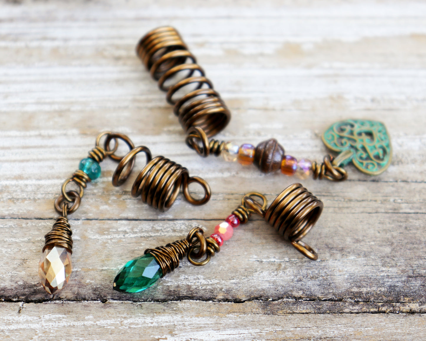 Set of 3 dreadlock beads on a wood background.