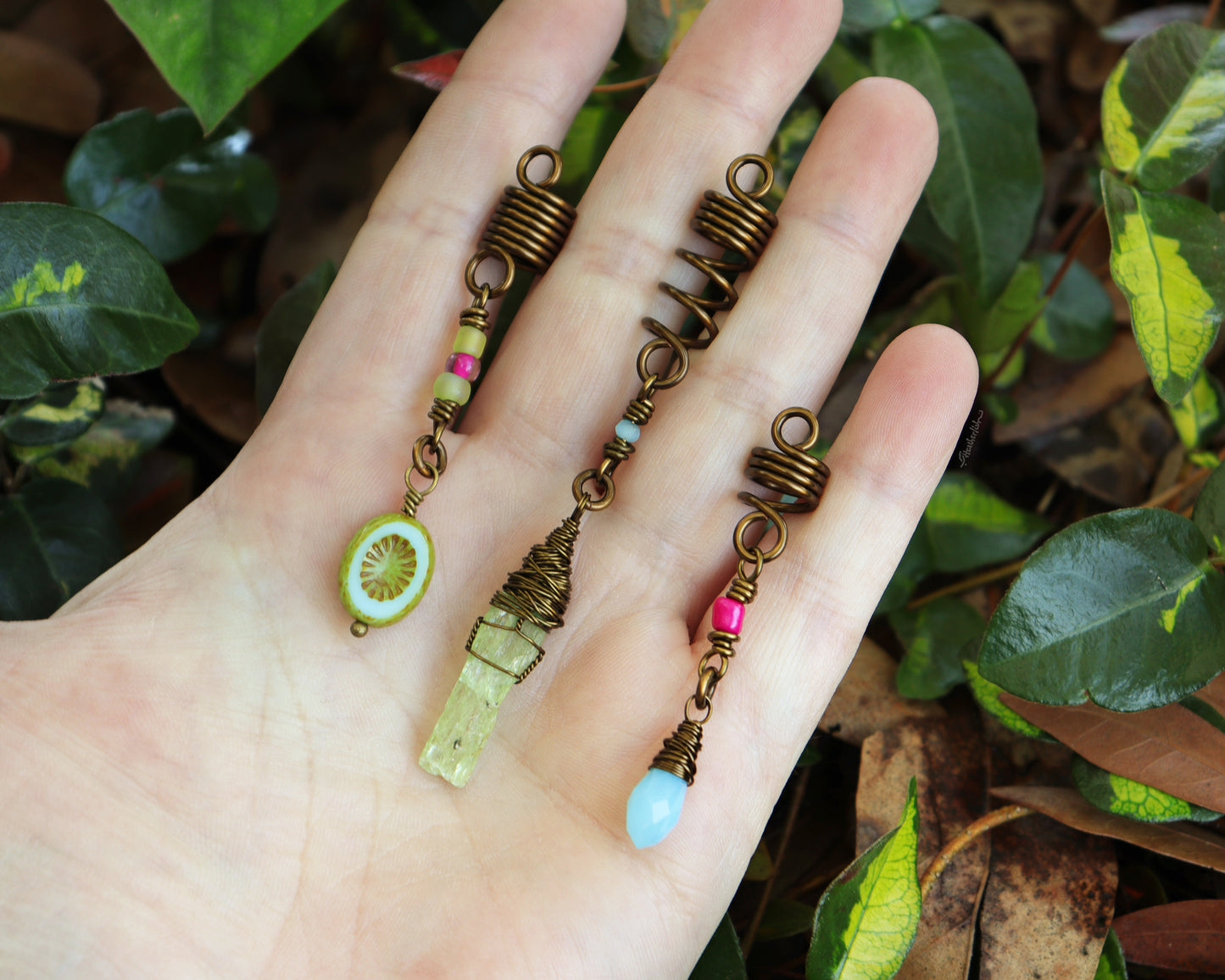 Spring themed set of three hair beads held in hand to show scale.