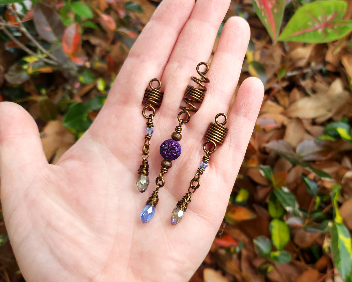 Set of 3 purple and periwinkle hair beads held in a hand to show scale.