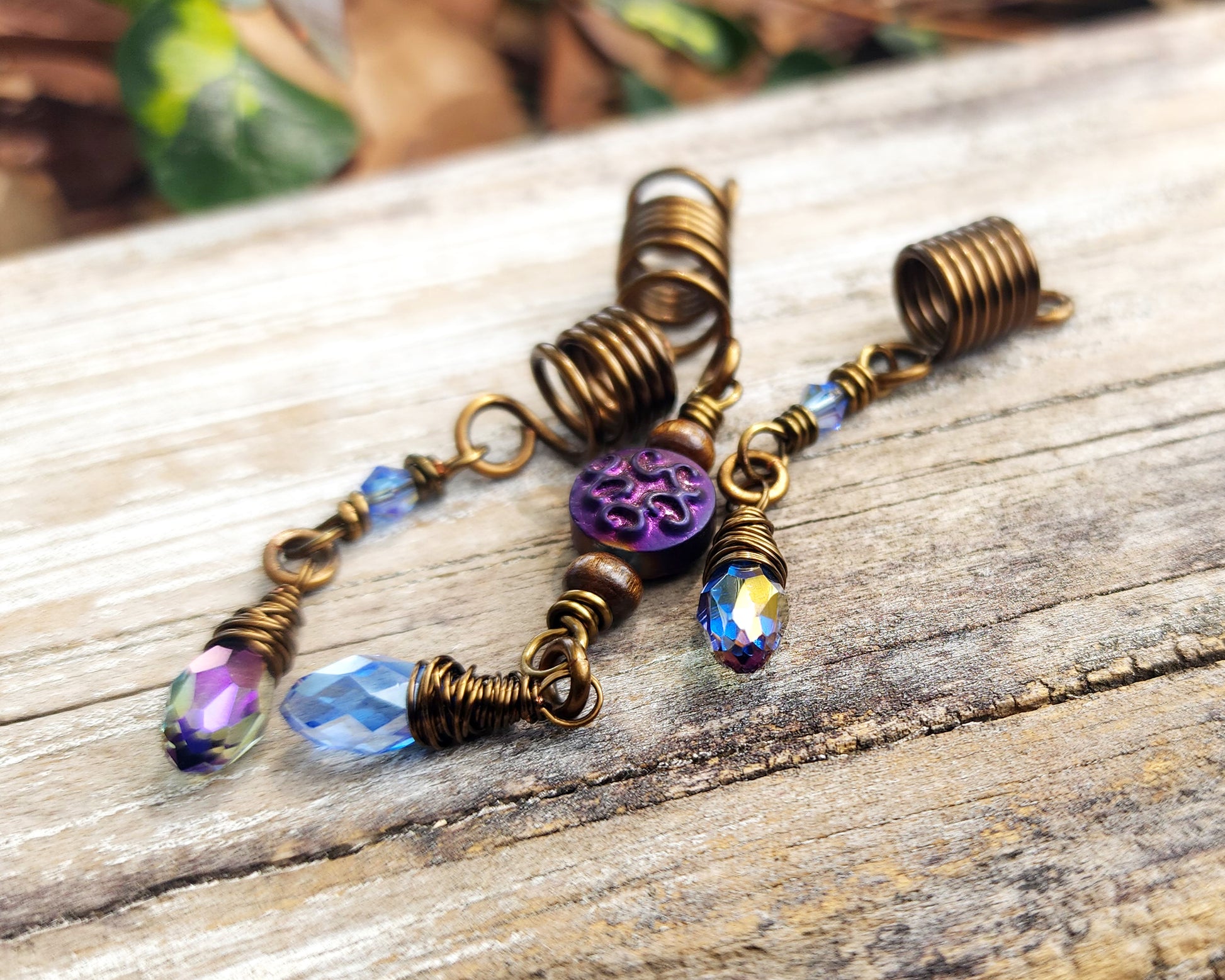 Set of 3 purple and periwinkle hair beads on a wood background.