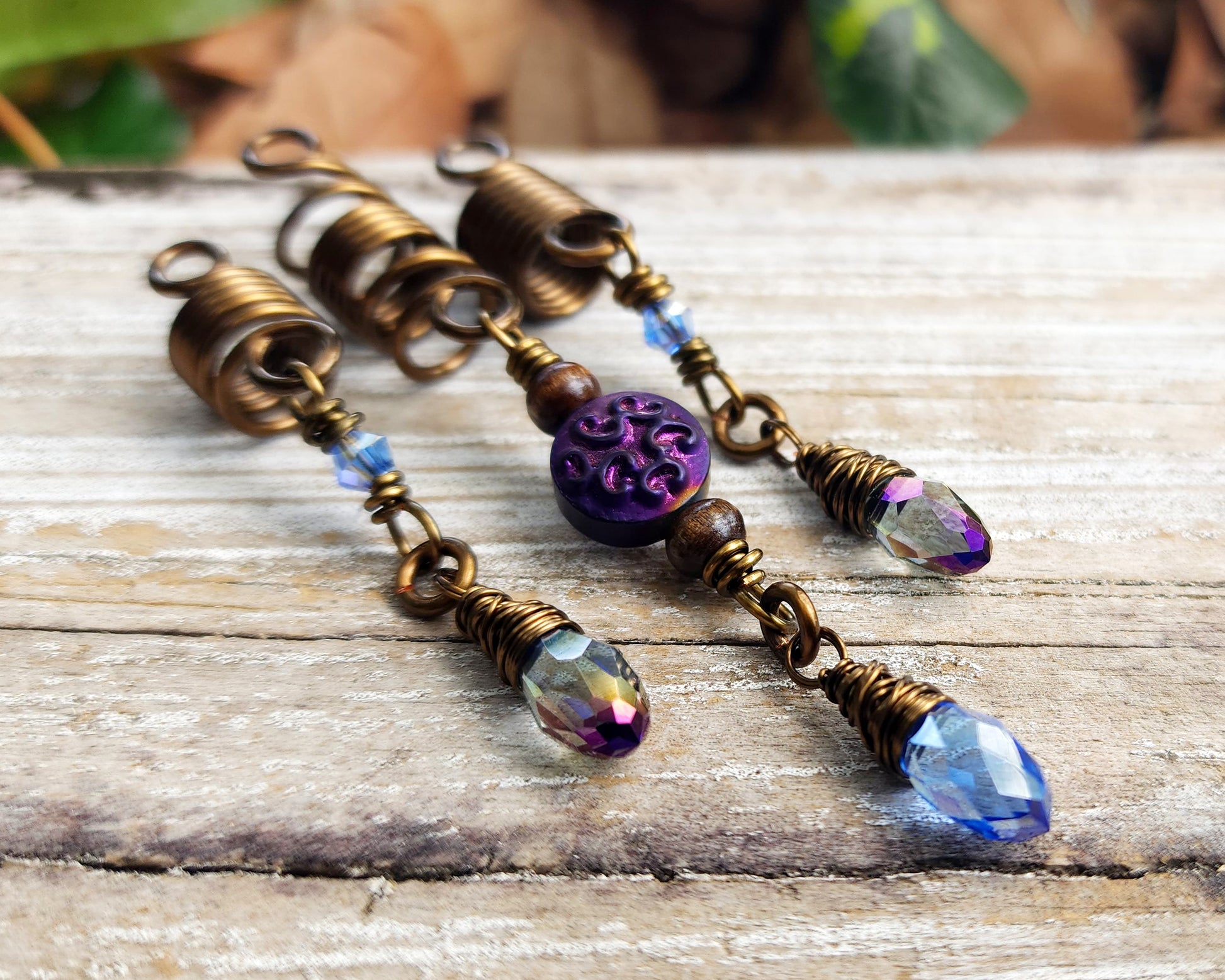 Set of 3 purple and periwinkle hair beads on a wood background.