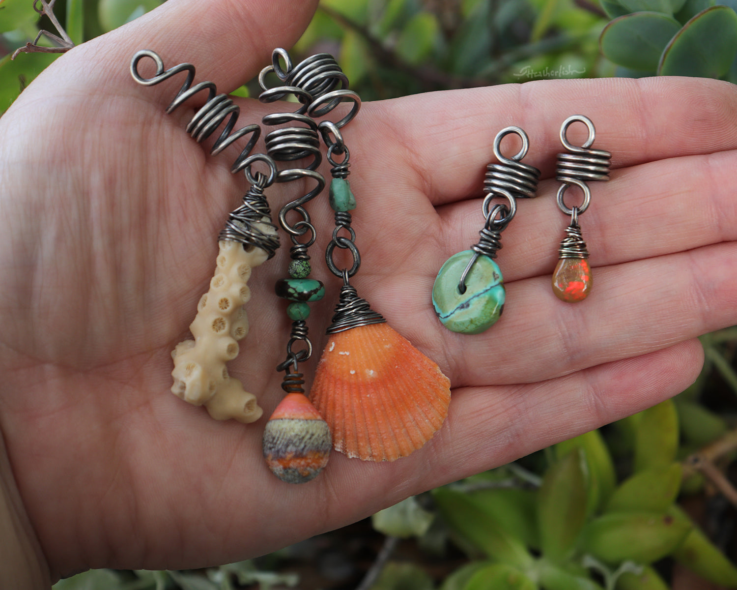 A set of five silver hair coils featuring an orange shell, white coral, orange artisan lampwork glass, Hubei Turquoise, aquamarine, and a Welo Ethiopian Opal.