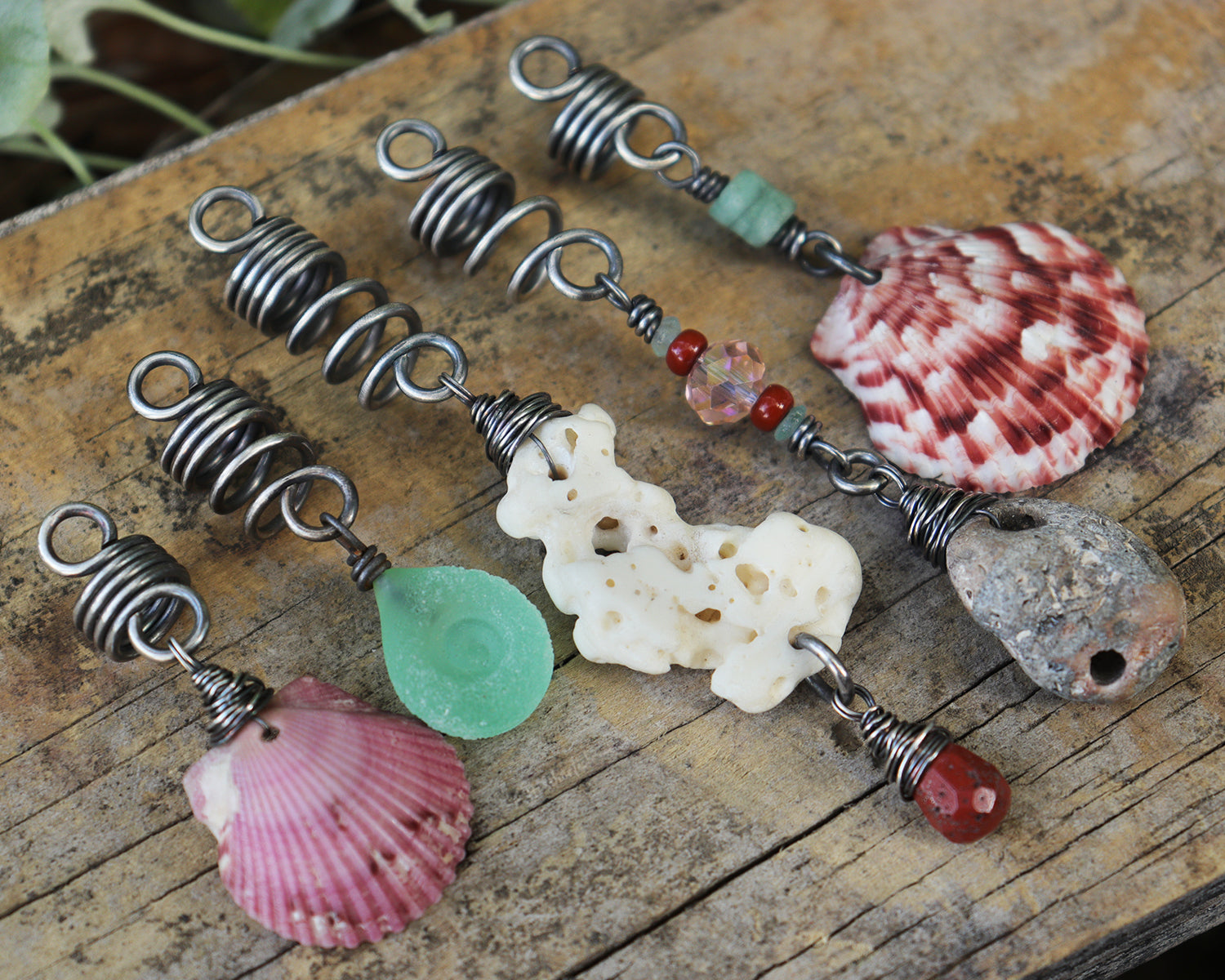 A set of 5 hair beads on silver coils featuring pink shells, coral, red jasper, sea green lampwork glass, a sea stone, and aquamarine.