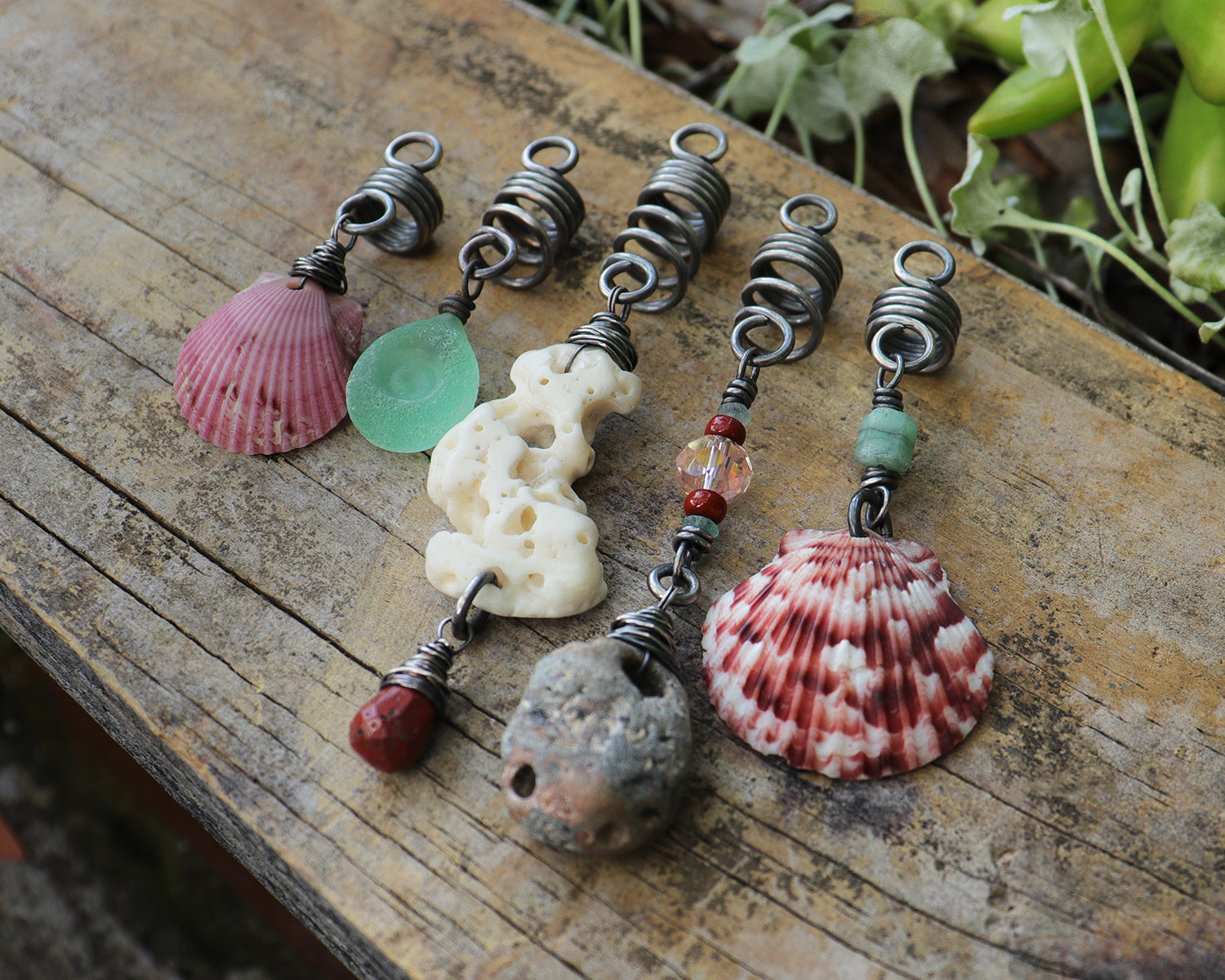 A set of 5 hair beads on silver coils featuring pink shells, coral, red jasper, sea green lampwork glass, a sea stone, and aquamarine.