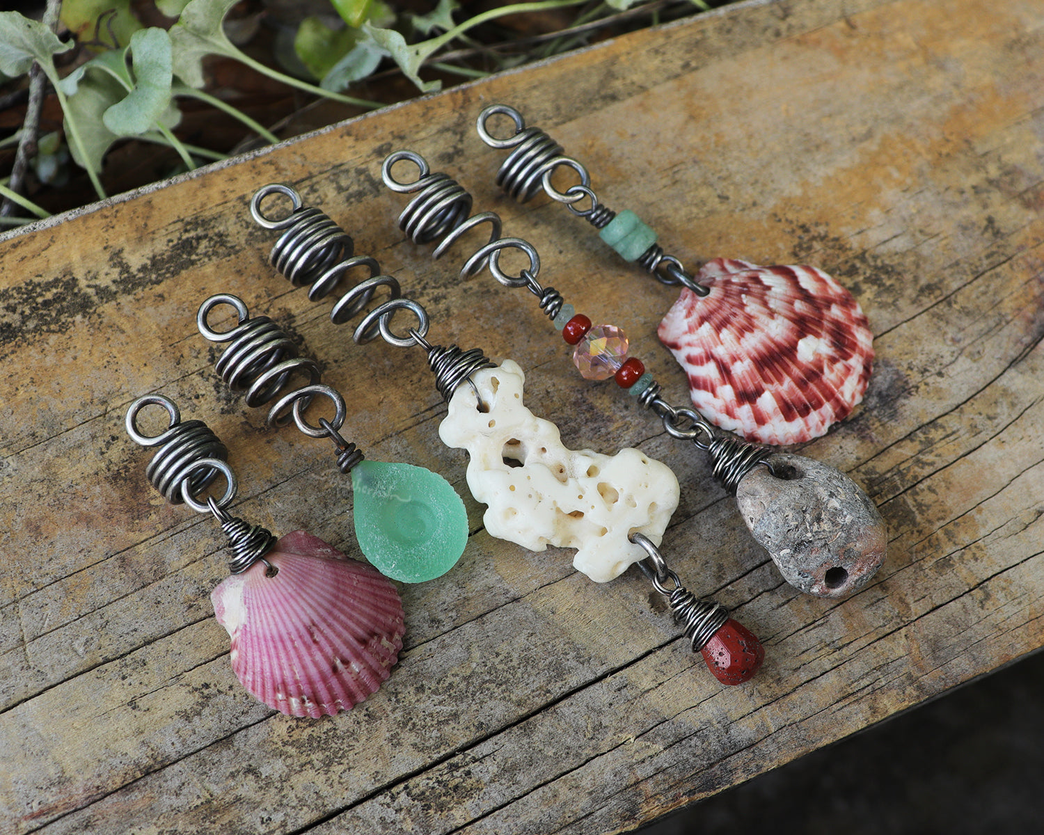 A set of 5 hair beads on silver coils featuring pink shells, coral, red jasper, sea green lampwork glass, a sea stone, and aquamarine.