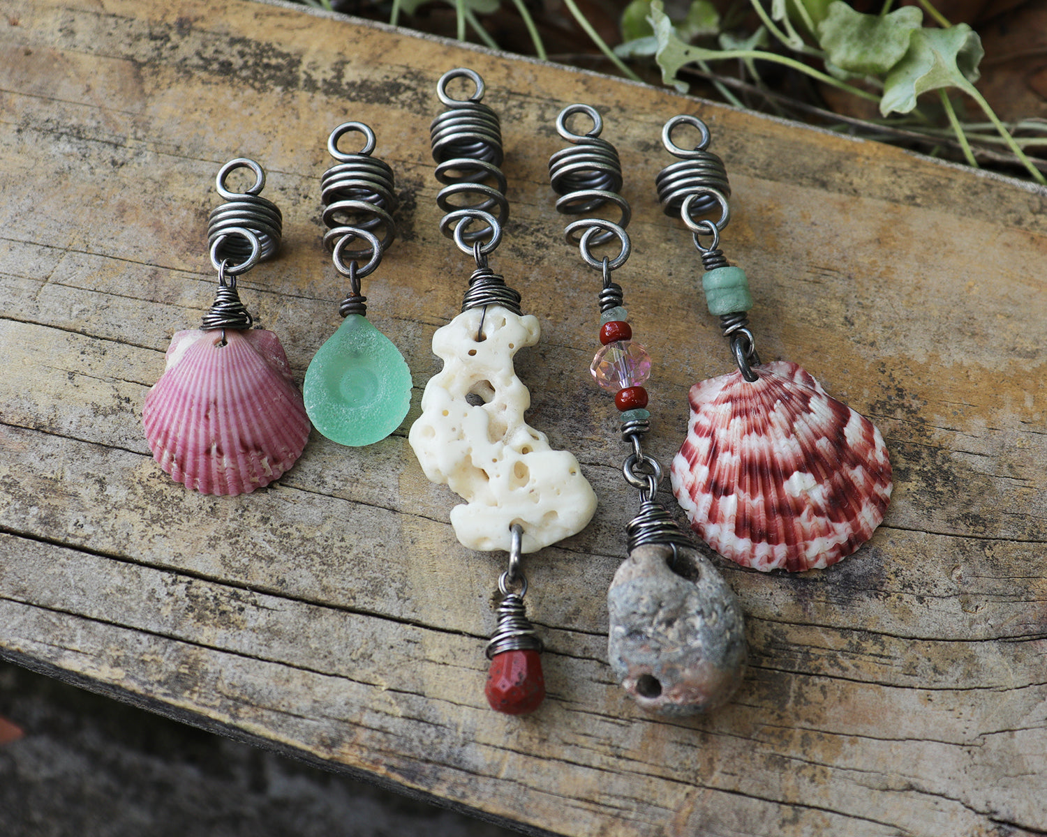 A set of 5 hair beads on silver coils featuring pink shells, coral, red jasper, sea green lampwork glass, a sea stone, and aquamarine.