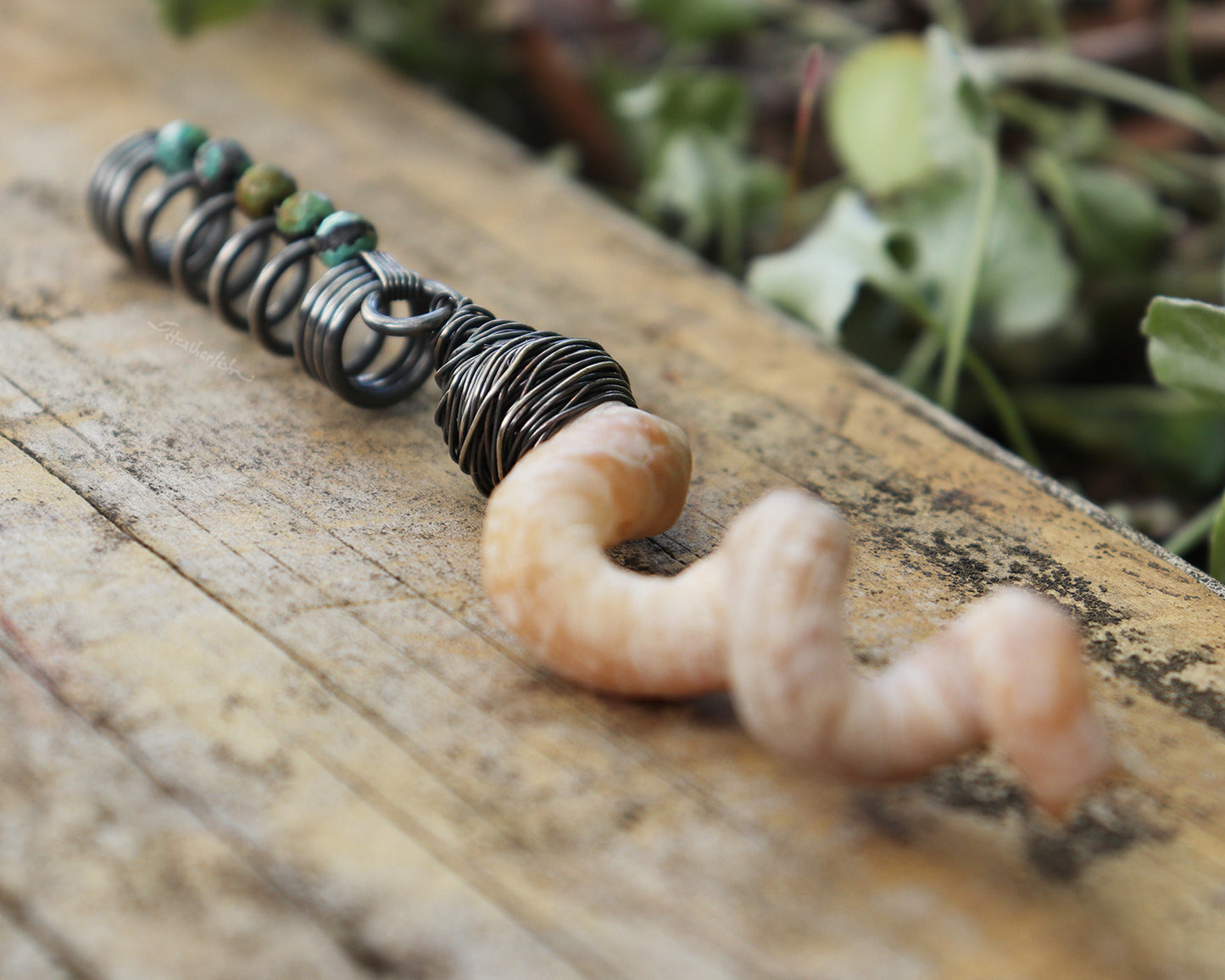 Hair jewelry featuring a silver coil accented with Hubei Turquoise beads and the spiral sea shell from a Florida tube snail.