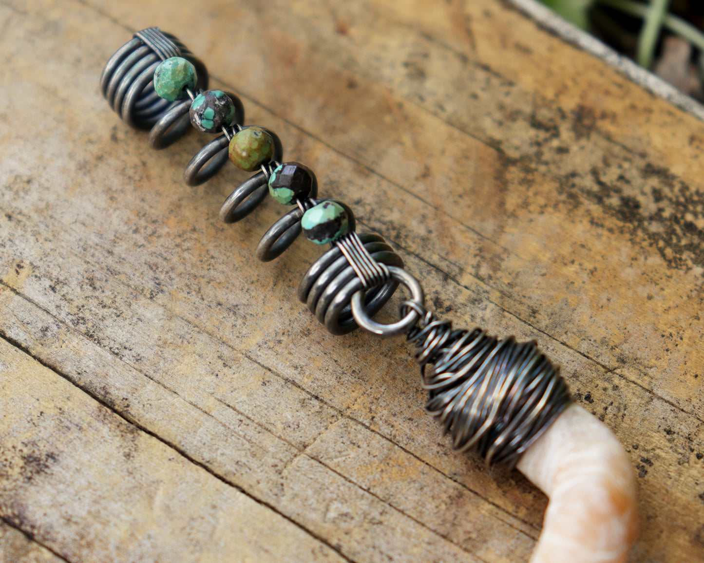 Hair jewelry featuring a silver coil accented with Hubei Turquoise beads and the spiral sea shell from a Florida tube snail.