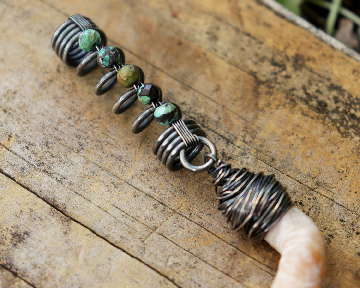 Hair jewelry featuring a silver coil accented with Hubei Turquoise beads and the spiral sea shell from a Florida tube snail.