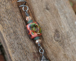 Hair Jewelry featuring a coral/raku lampwork glass bead and carved sea glass on a silver coil.