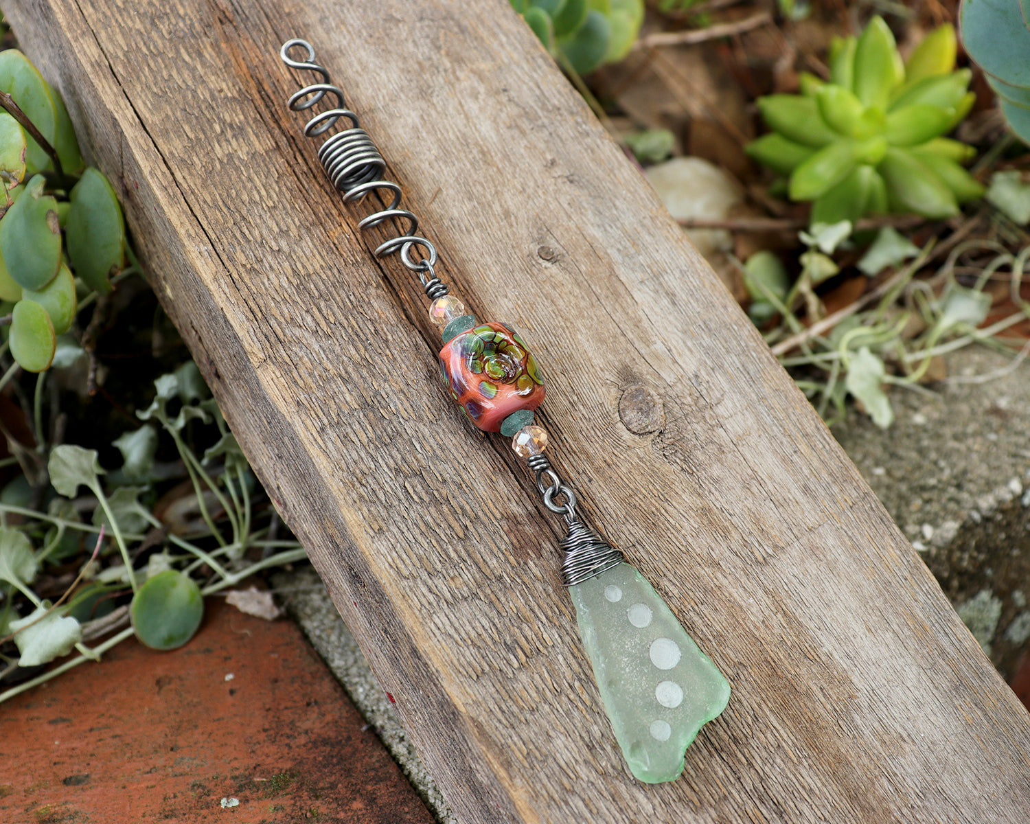 Hair Jewelry featuring a coral/raku lampwork glass bead and carved sea glass on a silver coil.