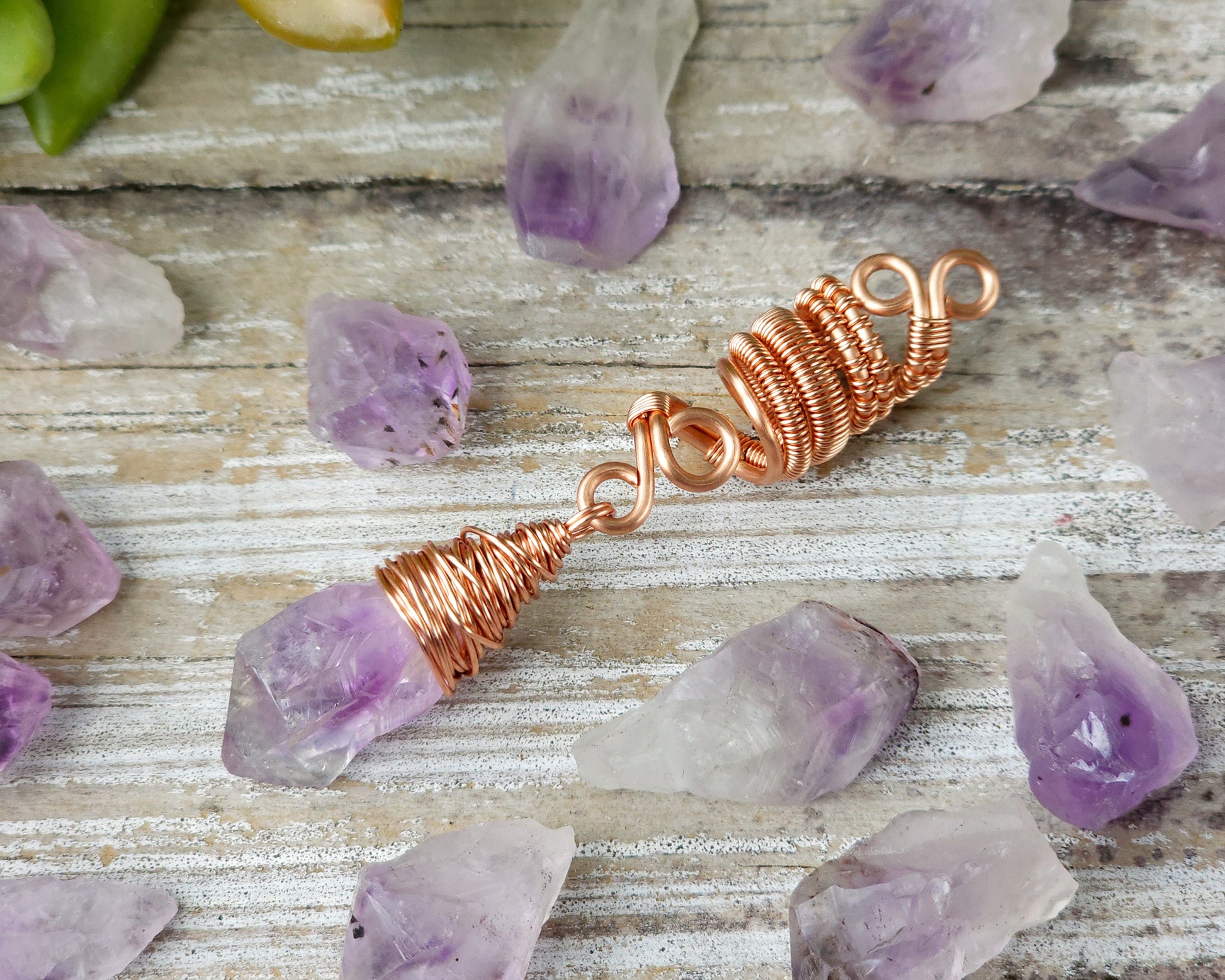 A woven copper dread bead featuring a raw Arkansas amethyst crystal point.