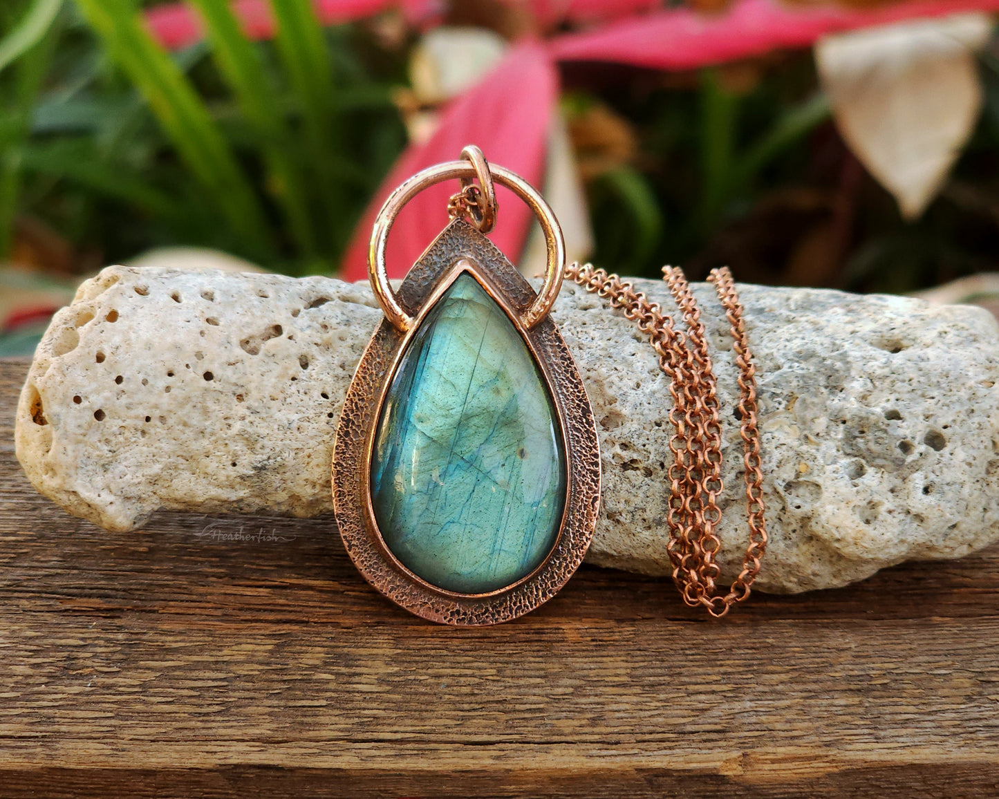 Teal labradorite and copper pendant necklace with copper chain on a rock with natural background