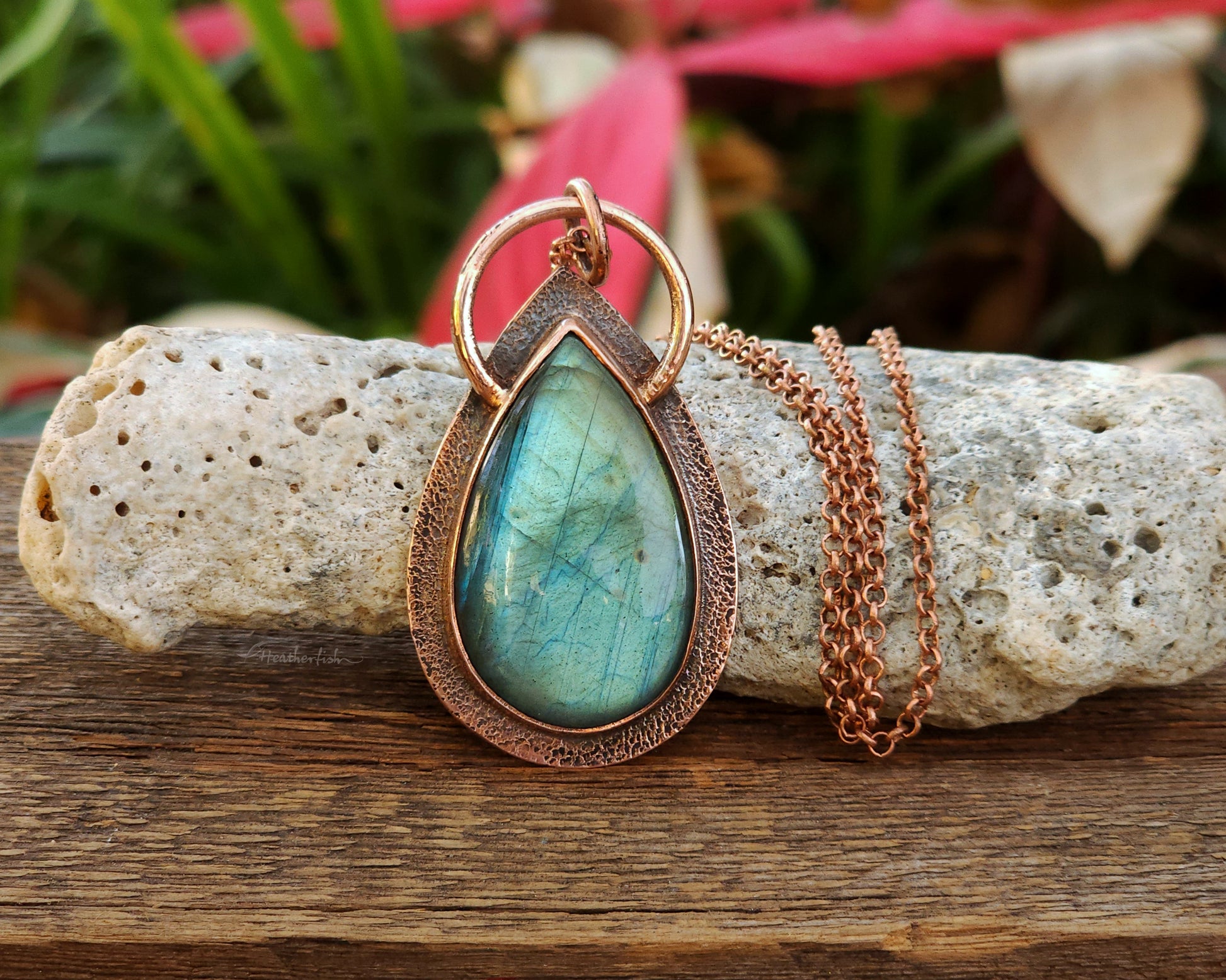 Teal labradorite and copper pendant necklace with copper chain on a rock with natural background