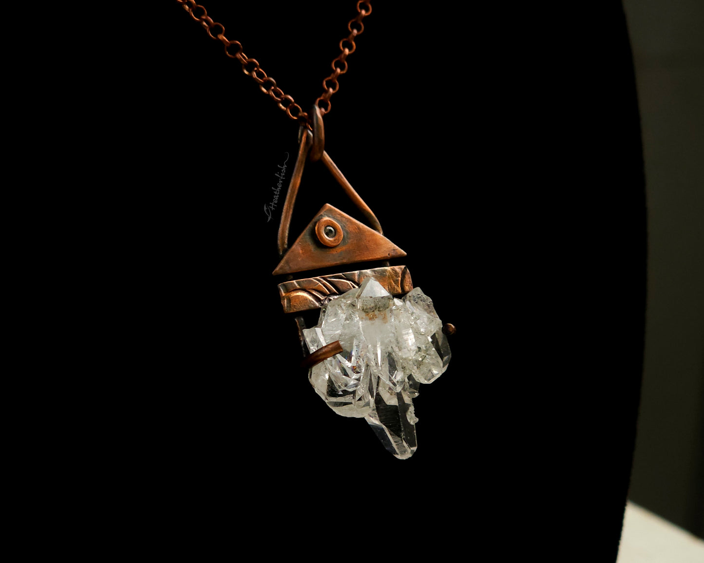 Necklace with a copper pendant and crystal on a black background