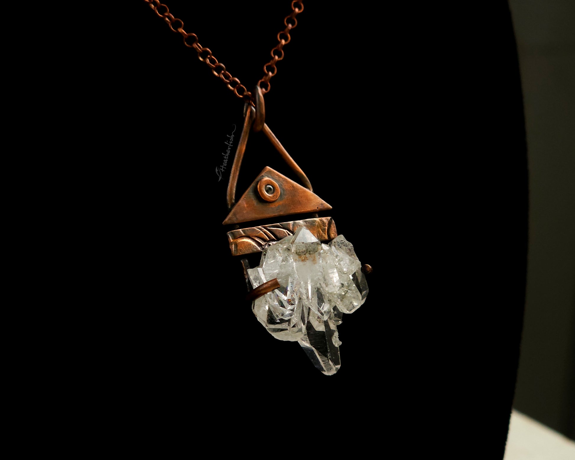 Necklace with a copper pendant and crystal on a black background