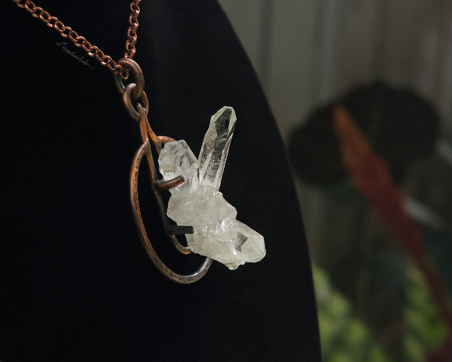 Crystal pendant on a chain against a dark background