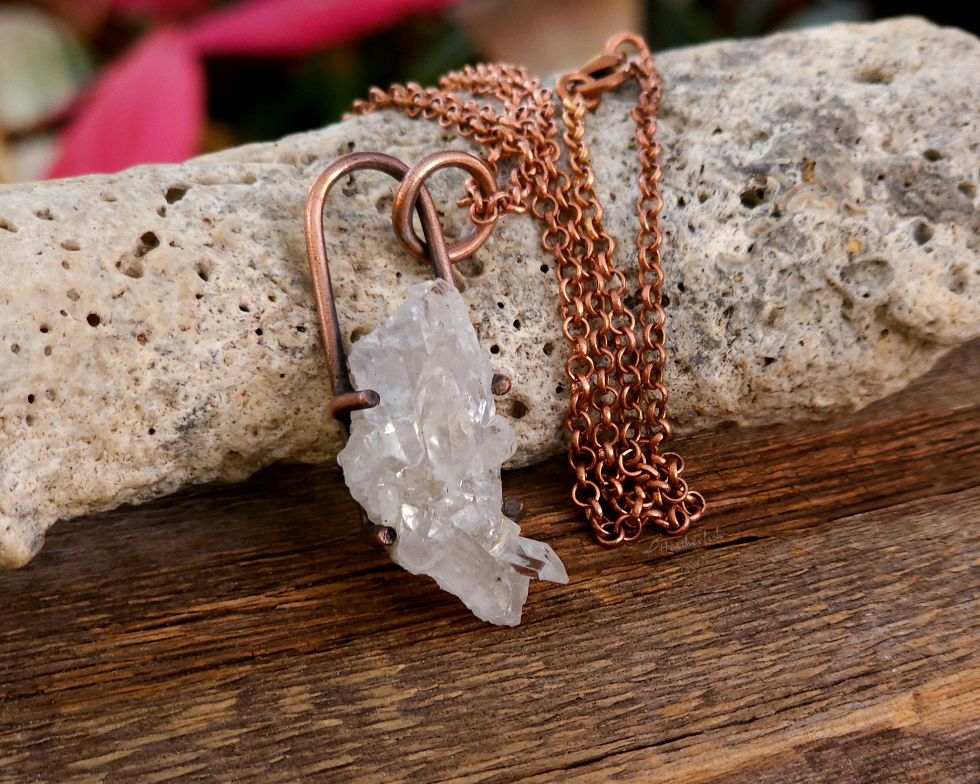 Quartz cluster necklace on a wood background.