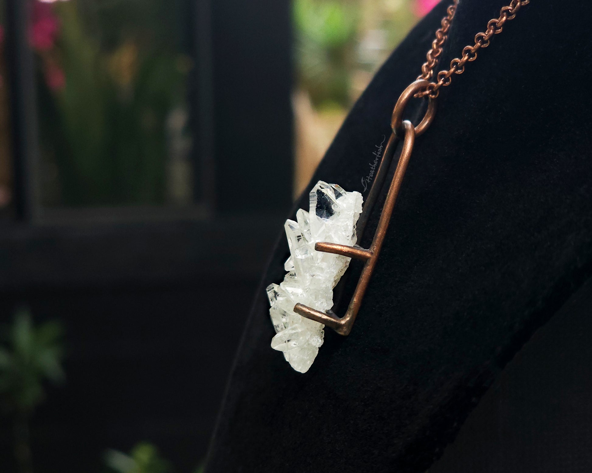 Quartz cluster necklace on a black background.