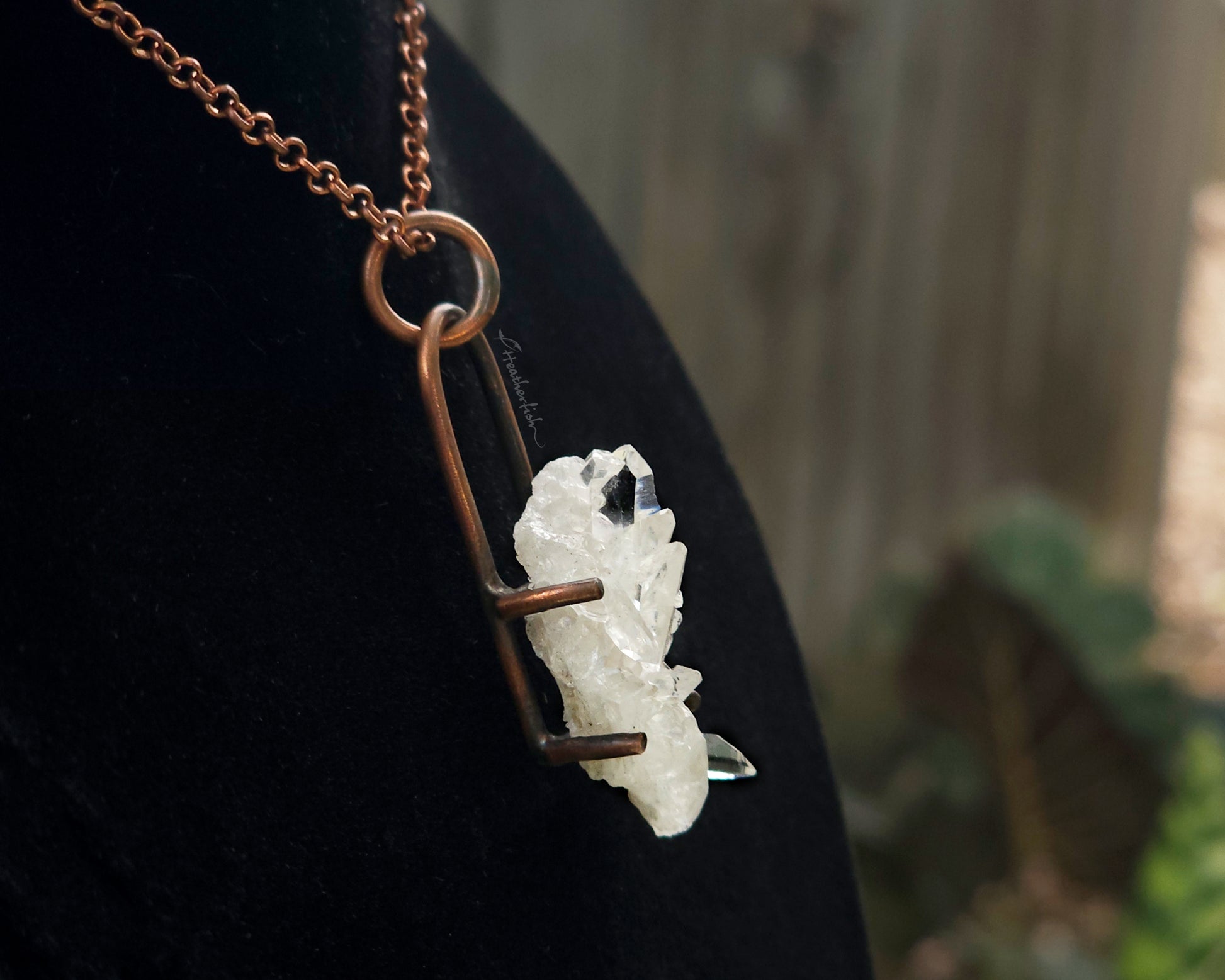 Quartz cluster necklace on a black background.