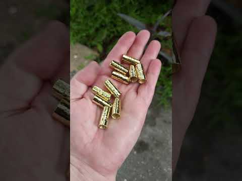 Brass hair cuffs held in hand with a natural background.