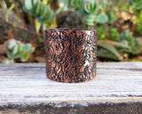 Copper hair cuff on wood background.