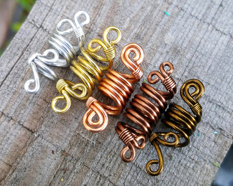 Top view of a set of 5 ombre dread beads on painted wood surface.