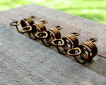 Set of 5 filigree beads on wood background.