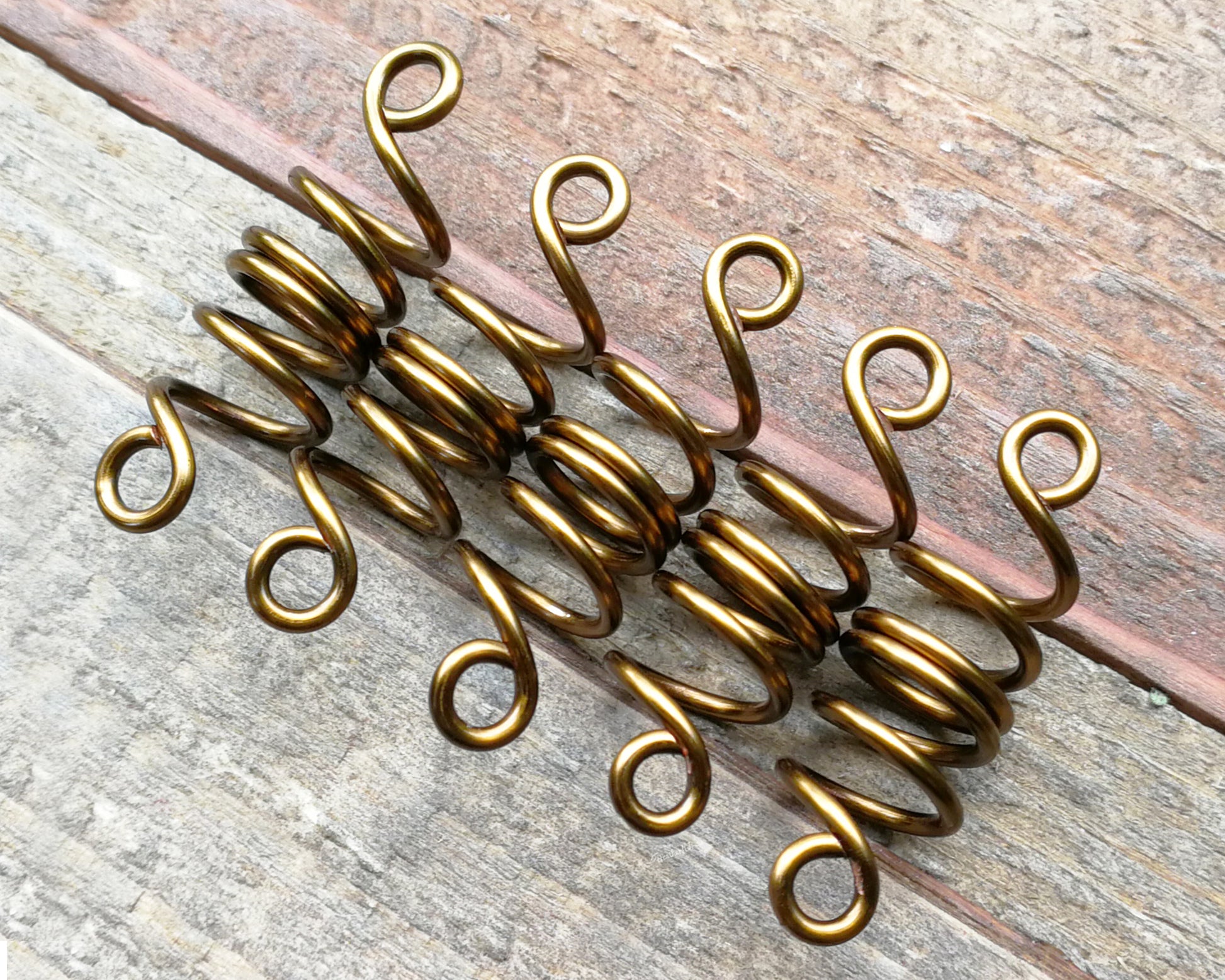 Set of 5 filigree beads on wood background.