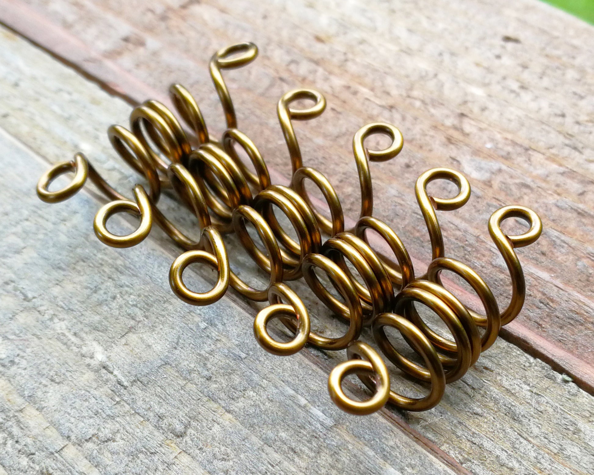 Set of 5 filigree beads on wood background.