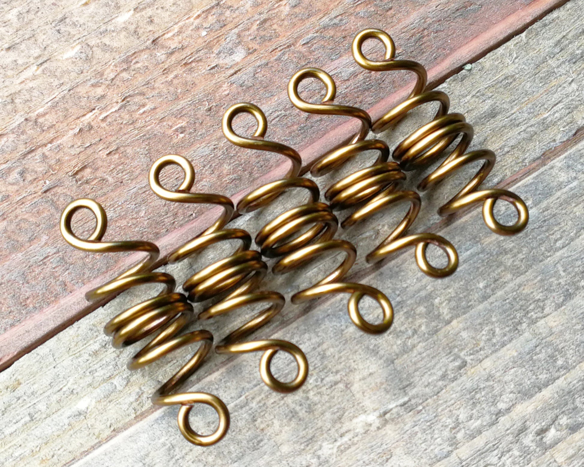 Set of 5 filigree beads on wood background.