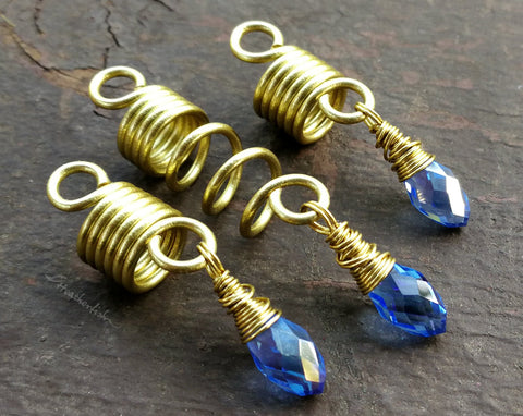 Set of 3 dread beads with periwinkle glass accents on a painted wood background.