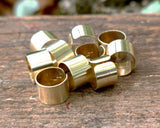 Set of 10 Brass Cuffs on a wood background.