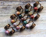 Set of 5 jasper dread beads on white washed wood background.