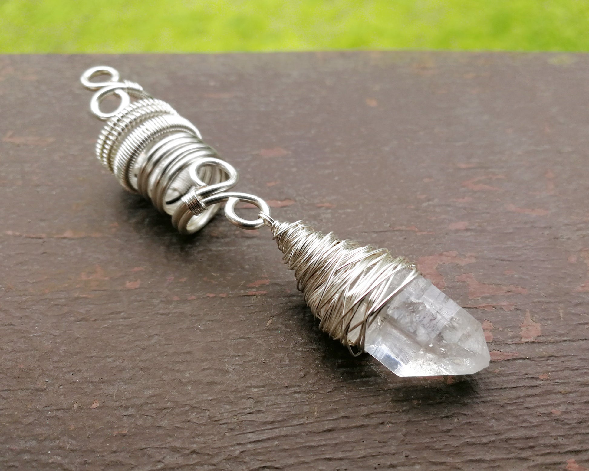 Woven Silver Dread Bead featuring and arkansas quartz crystal on a painted wood background.