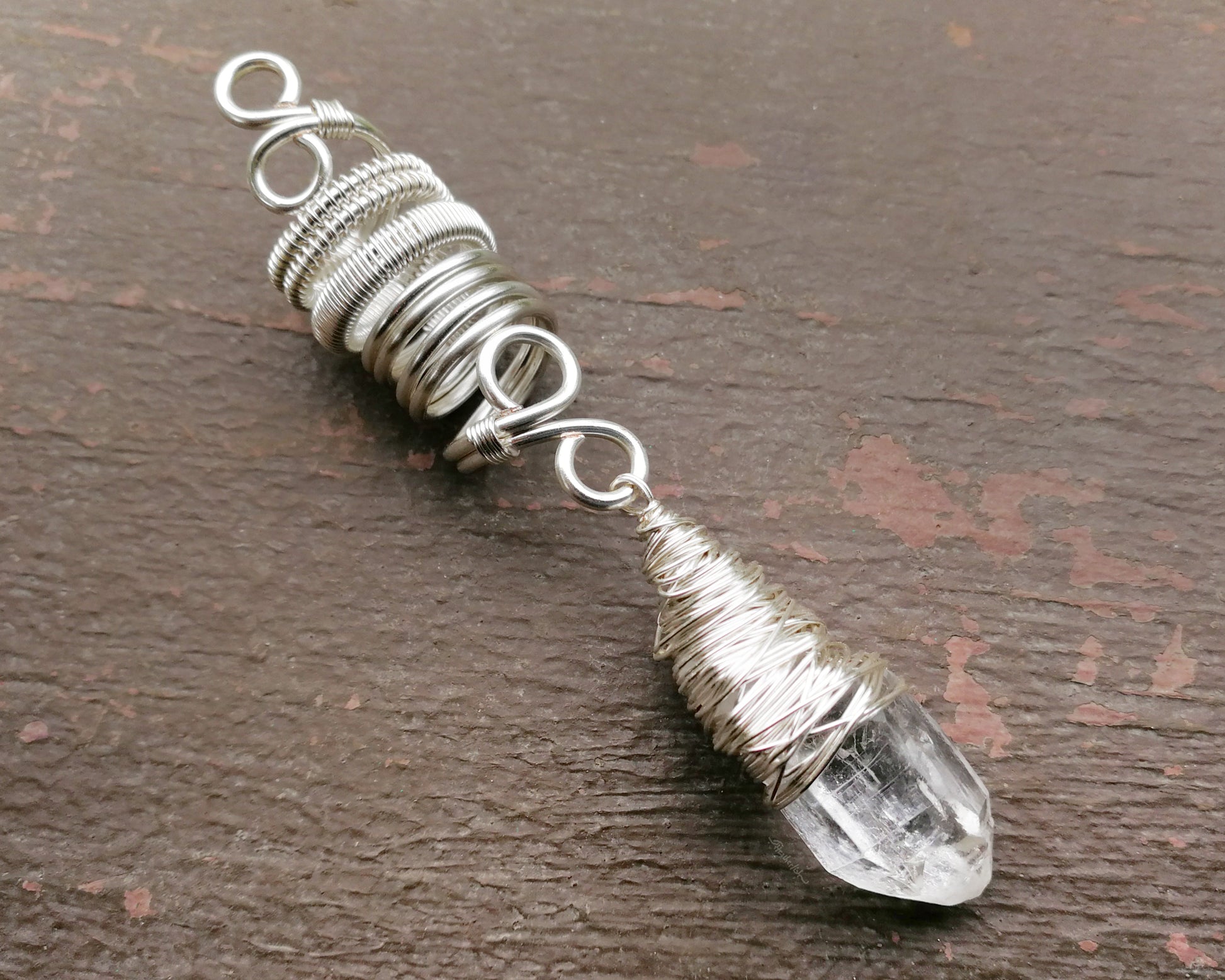 Woven Silver Dread Bead featuring and arkansas quartz crystal on a painted wood background.