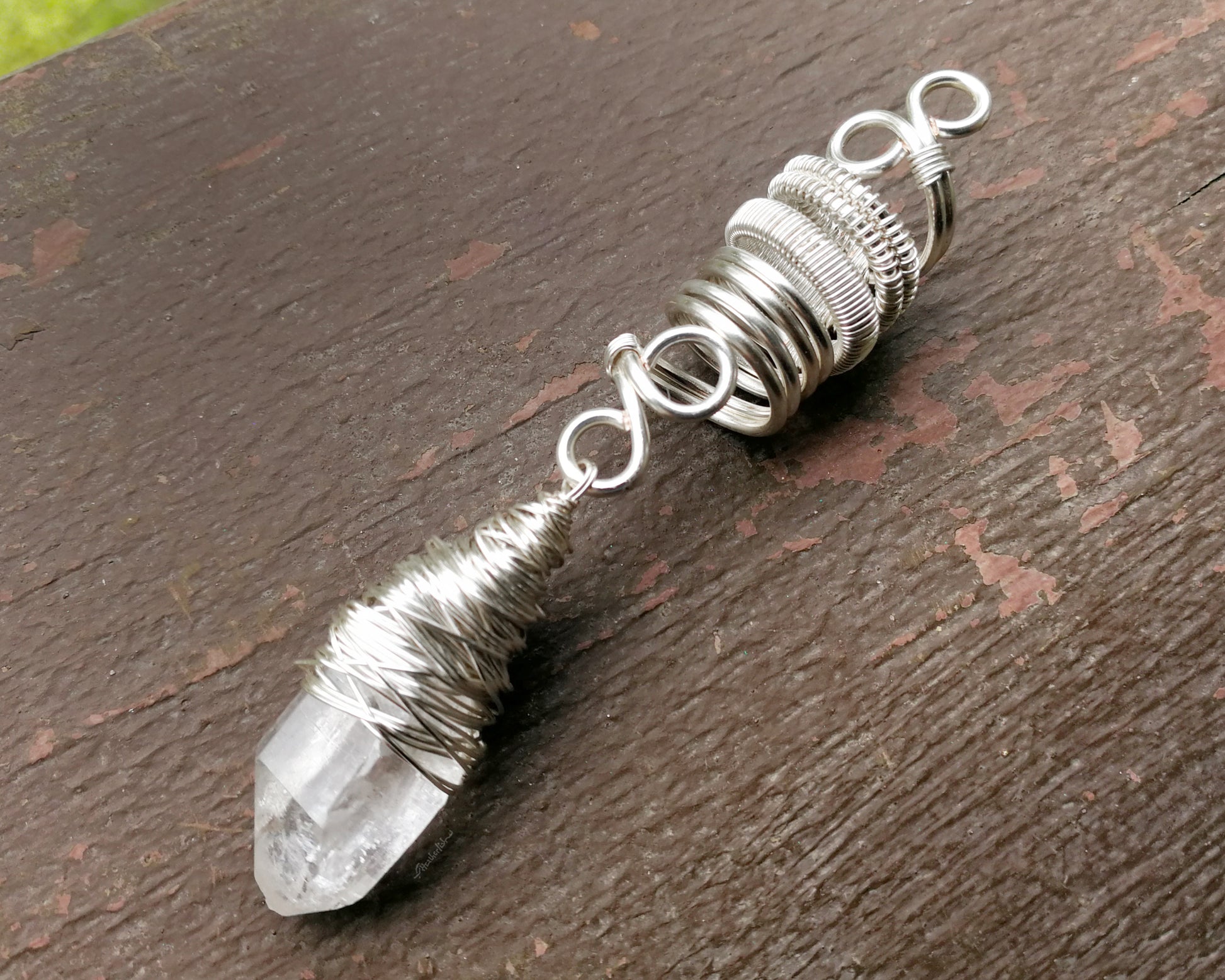 Woven Silver Dread Bead featuring and arkansas quartz crystal on a painted wood background.