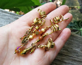A top view of a Set of 5 Gold Amber Loc Beads in hand.