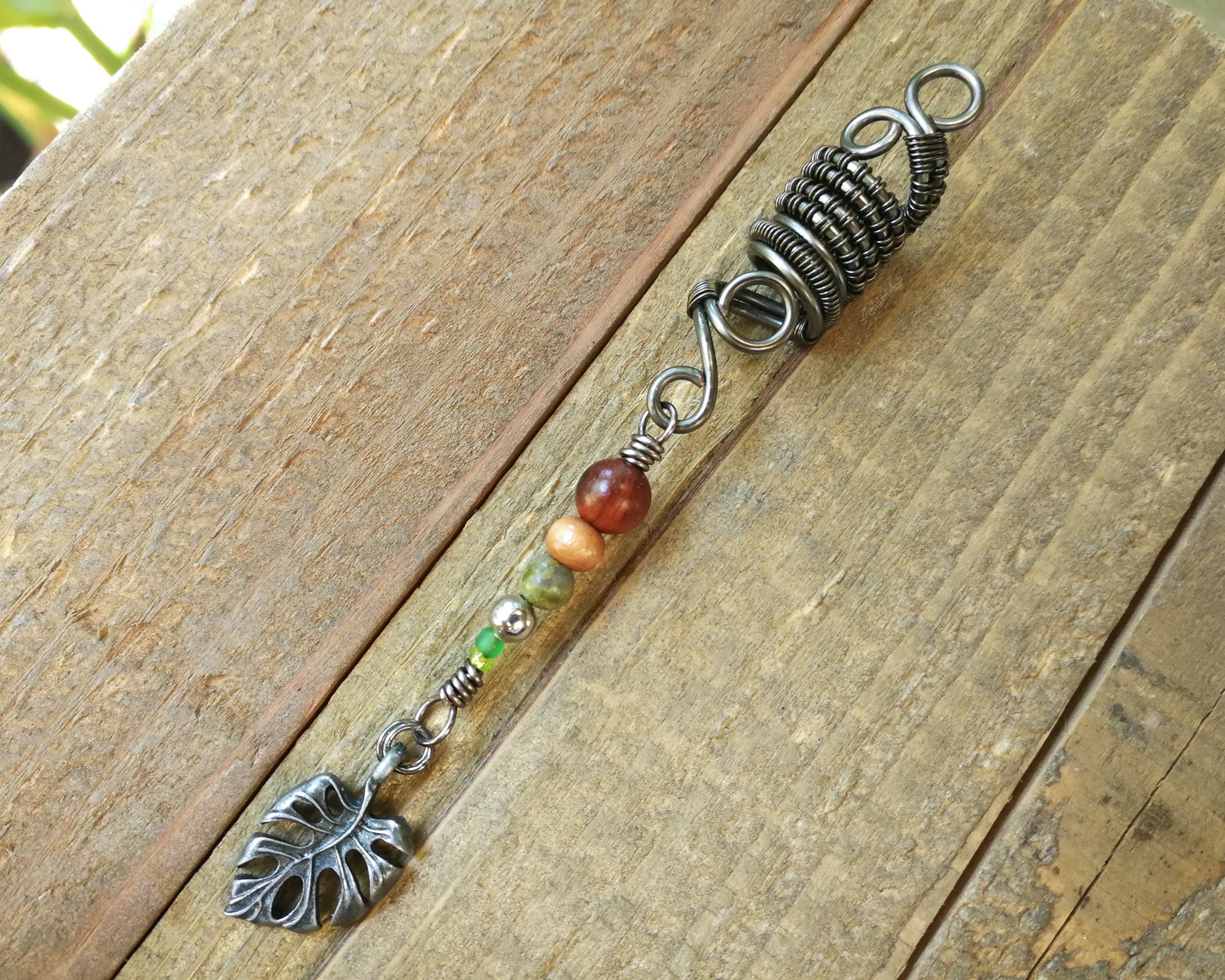A back view of a Hematite Leaf Dread Bead.