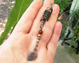 A top view of a Hematite Leaf Dread Bead in hand.