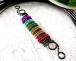 A side view of a Rainbow Pride Dread Bead.