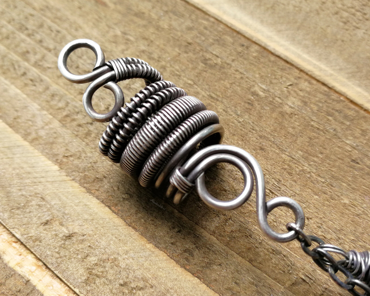 Silver Crystal Dread Bead, Ivory Inclusions on wood background. Close up of woven coil.