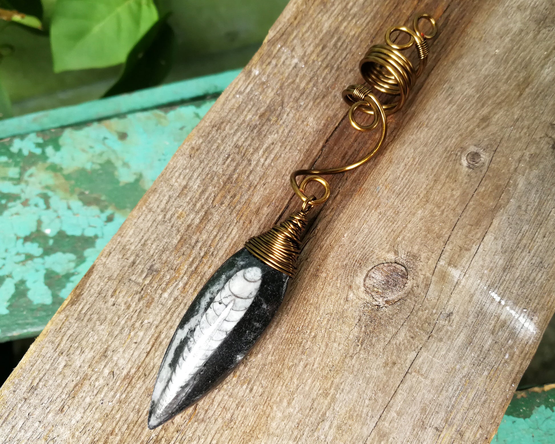 Orthoceras Fossil Dread Bead on wood background.