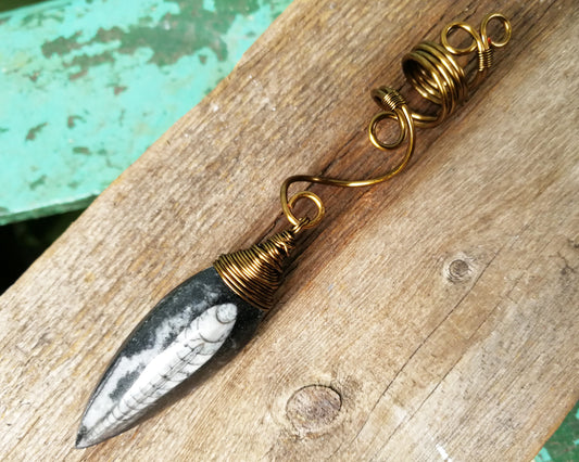 Orthoceras Fossil Dread Bead on wood background.