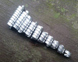 Set of 10 varied length aluminum dread beads in a row