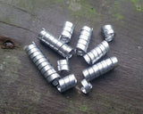 Set of 10 varied length aluminum dread beads in pile