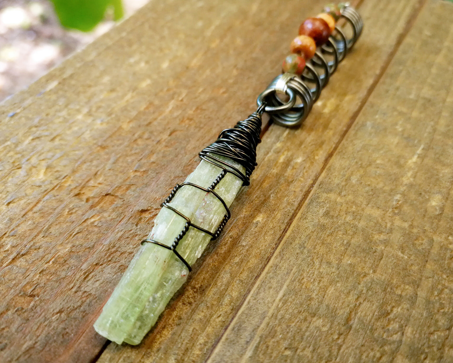 Green Kyanite, Hematite Dread Bead on wood background.