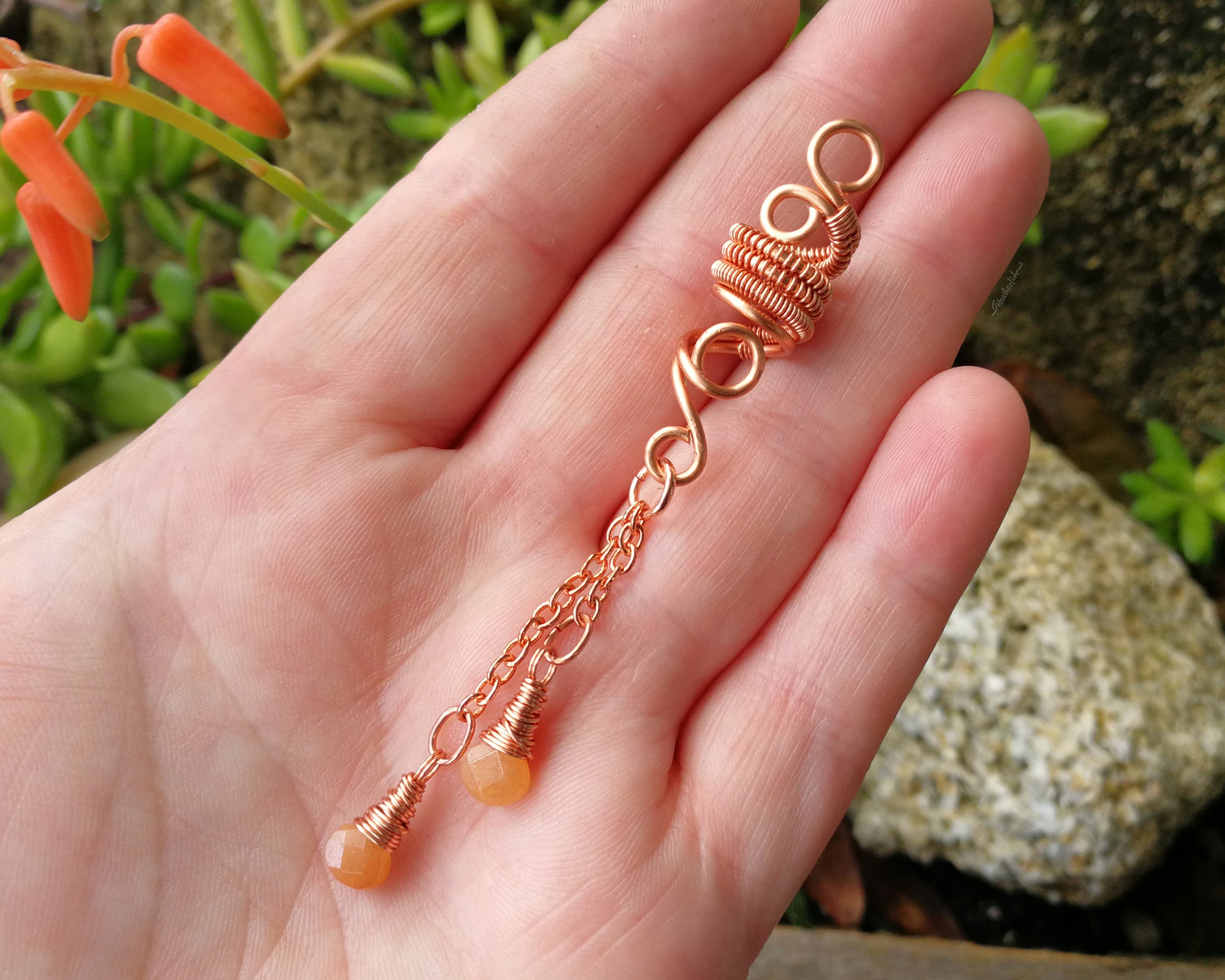 An aventurine hair jewel held in a hand to show scale.