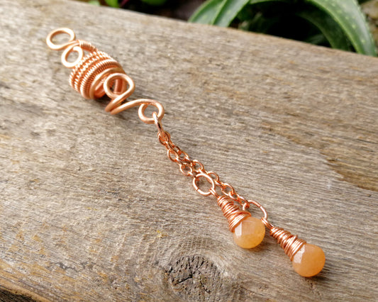 An aventurine hair jewel on a wood background.