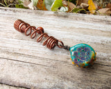 Glass Sunflower Dread Bead on a wood background.